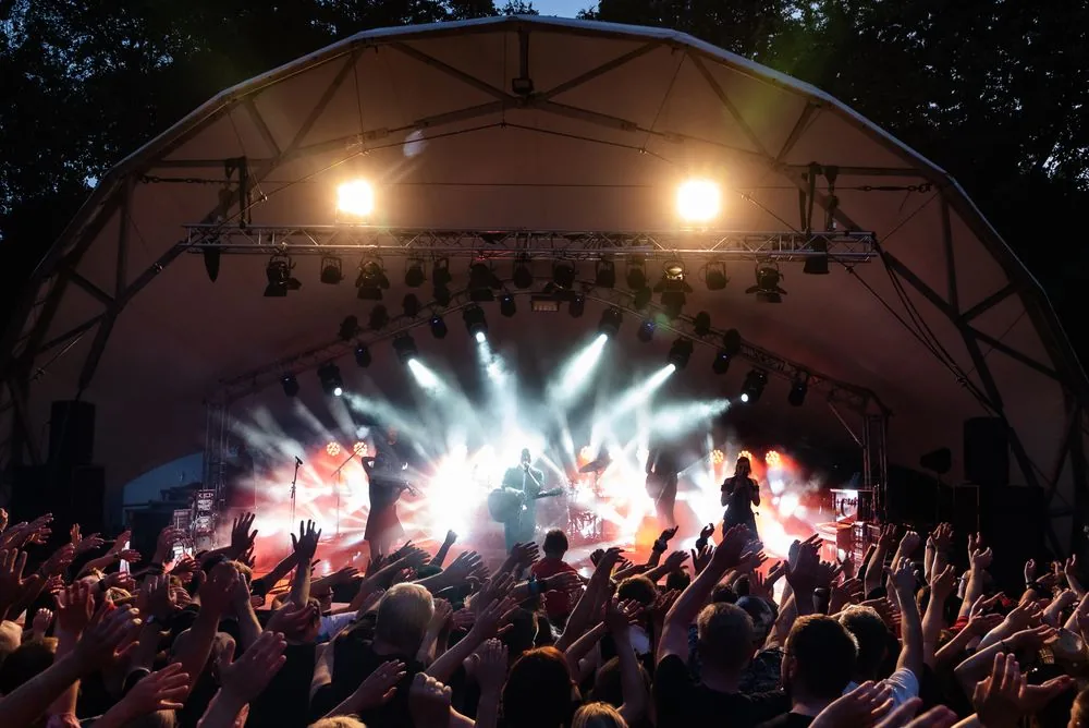 Concert audience facing a brightly lit live stage